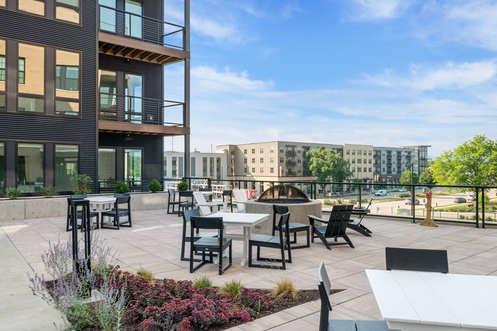 an outdoor patio with tables and chairs and a fire pit